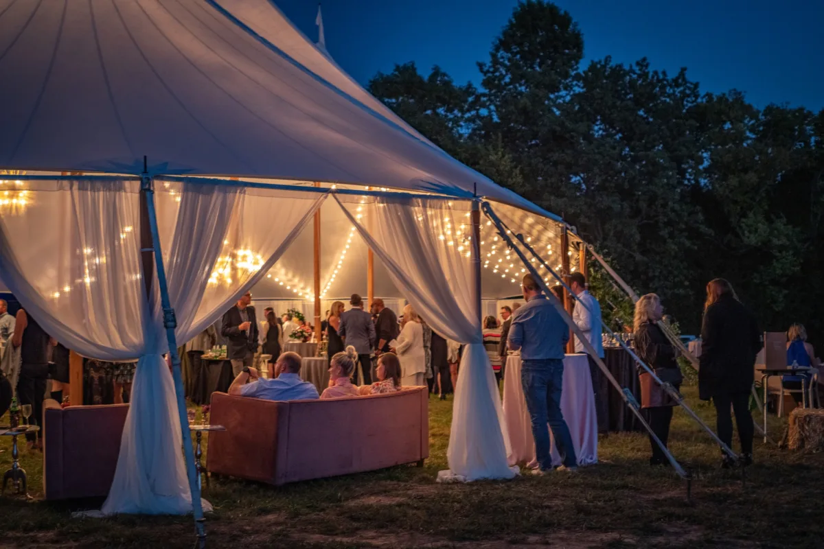 Elegant outdoor corporate event under white tent with string lights and catering service by A Catered Affair in Nashville