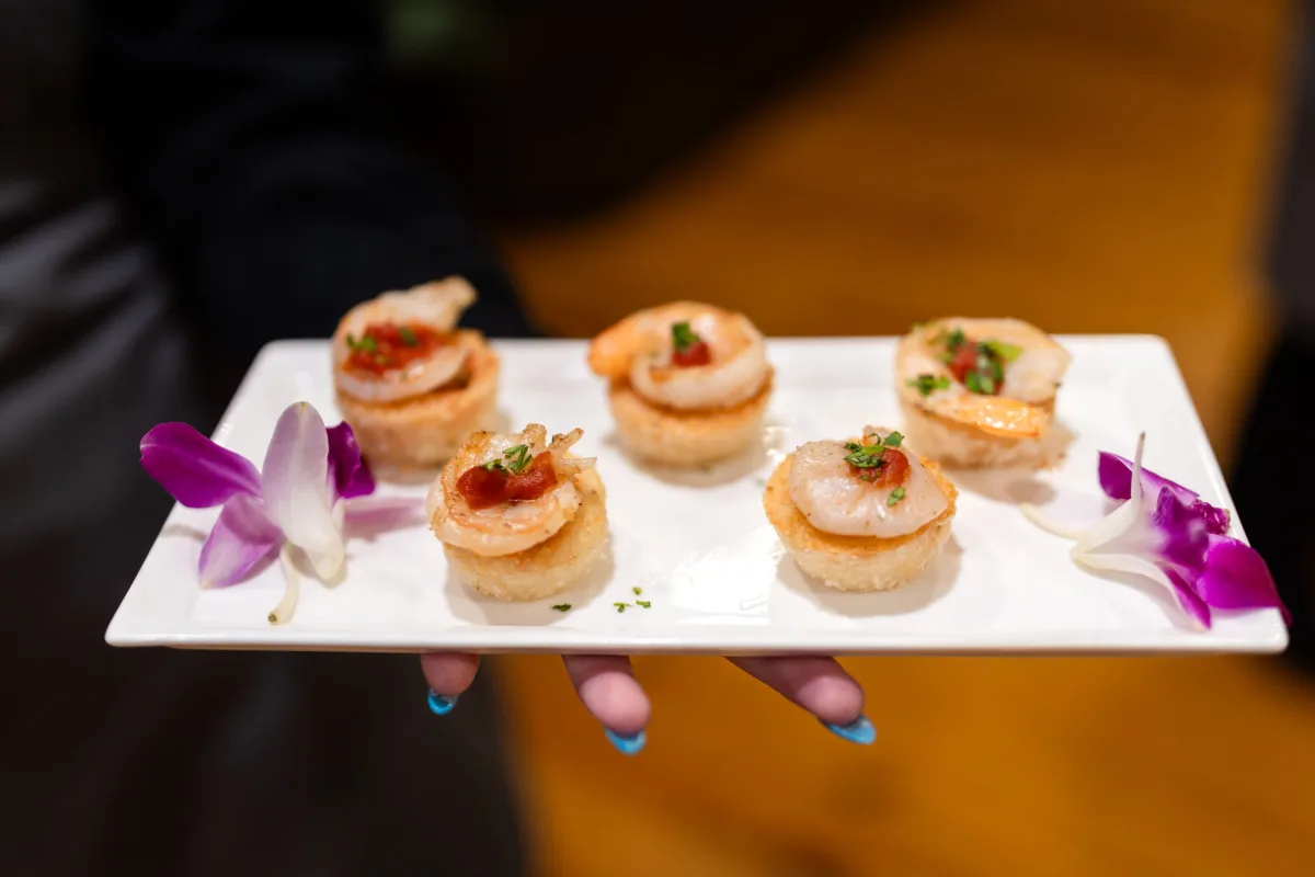 Elegant sushi appetizers with white orchid garnish served on white platter by A Catered Affair Nashville wedding caterer