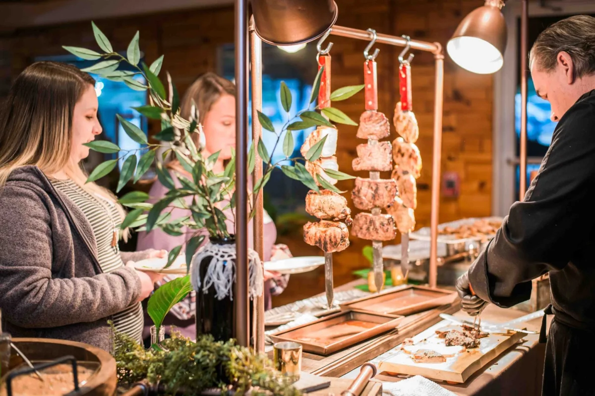 A Catered Affair presents an elegant charcuterie and meat carving station at a Nashville corporate event with professional service staff