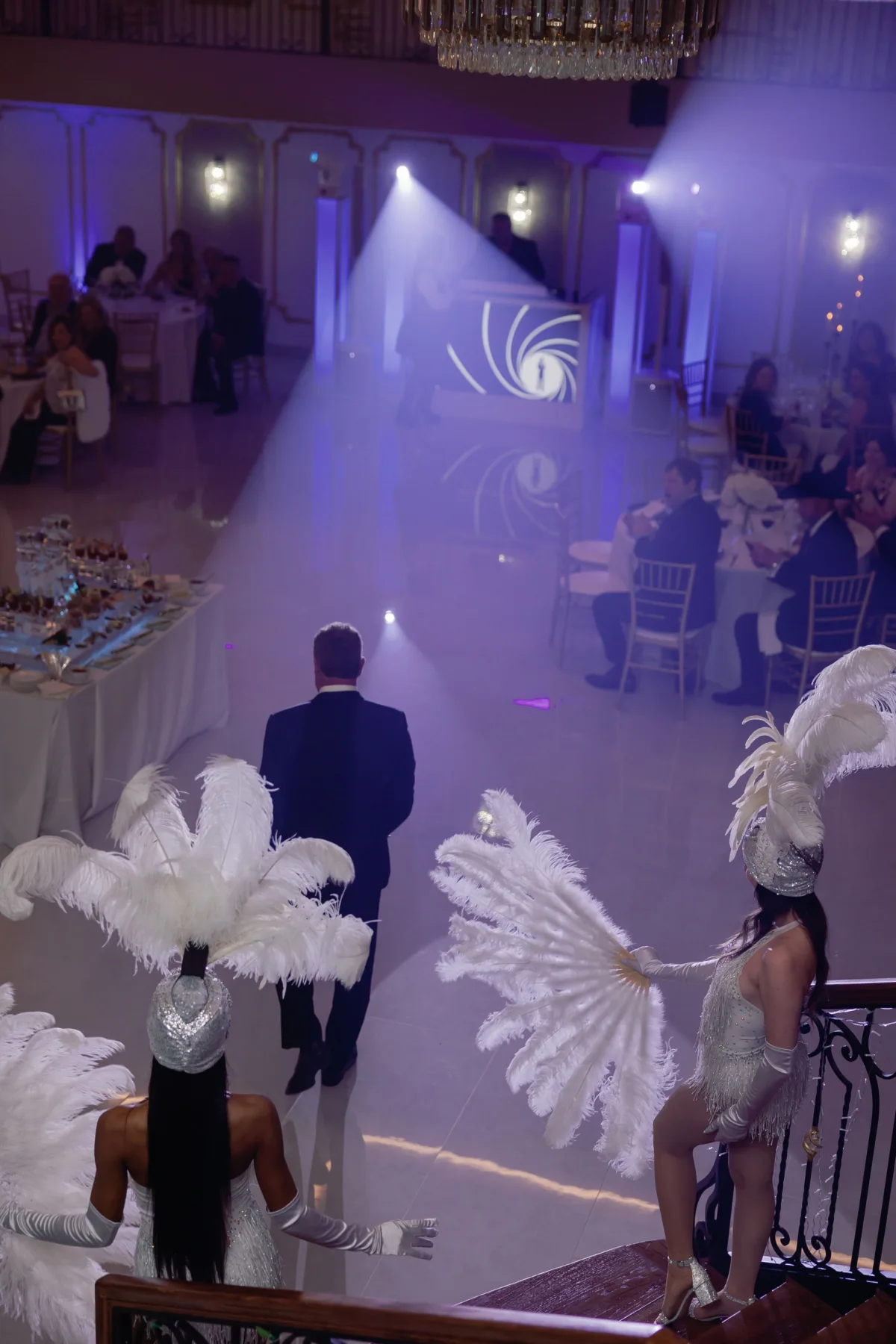 Elegant private event entertainment with feathered performers in purple-lit Nashville ballroom by A Catered Affair