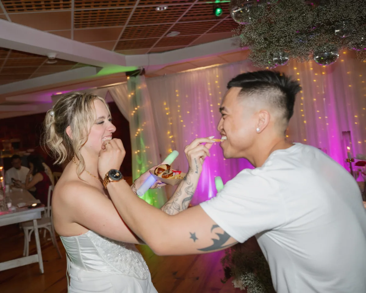 Happy couple feeding each other wedding cake during their Nashville wedding reception catered by A Catered Affair