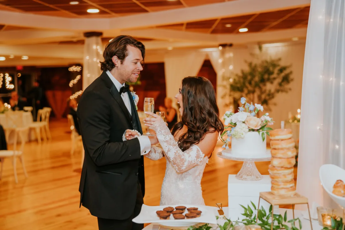 Bride and groom toasting champagne during wedding cake cutting ceremony at Nashville wedding reception catered by A Catered Affair