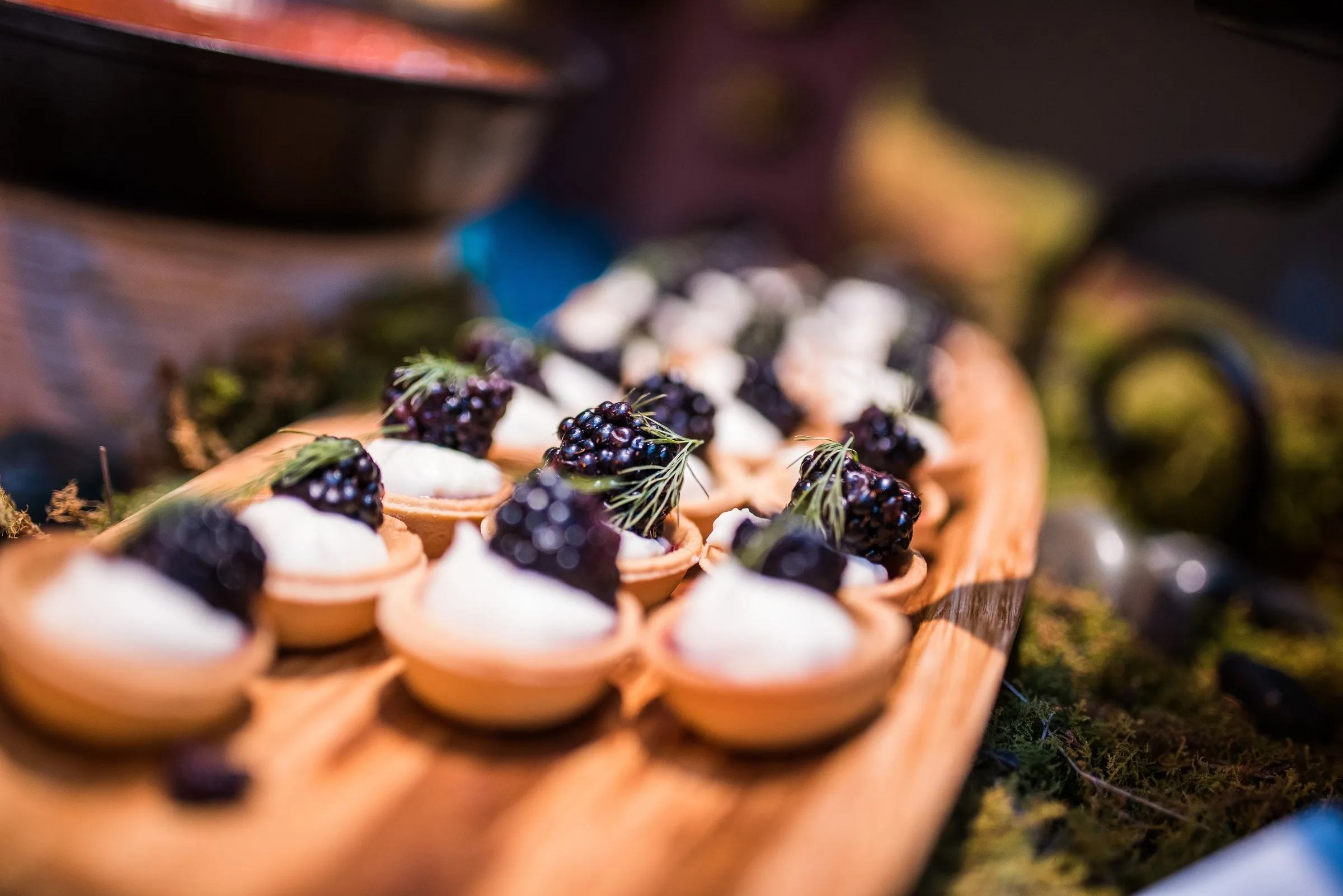 Elegant gourmet appetizers with caviar and cream garnish on wooden spoons created by Nashville wedding caterer A Catered Affair