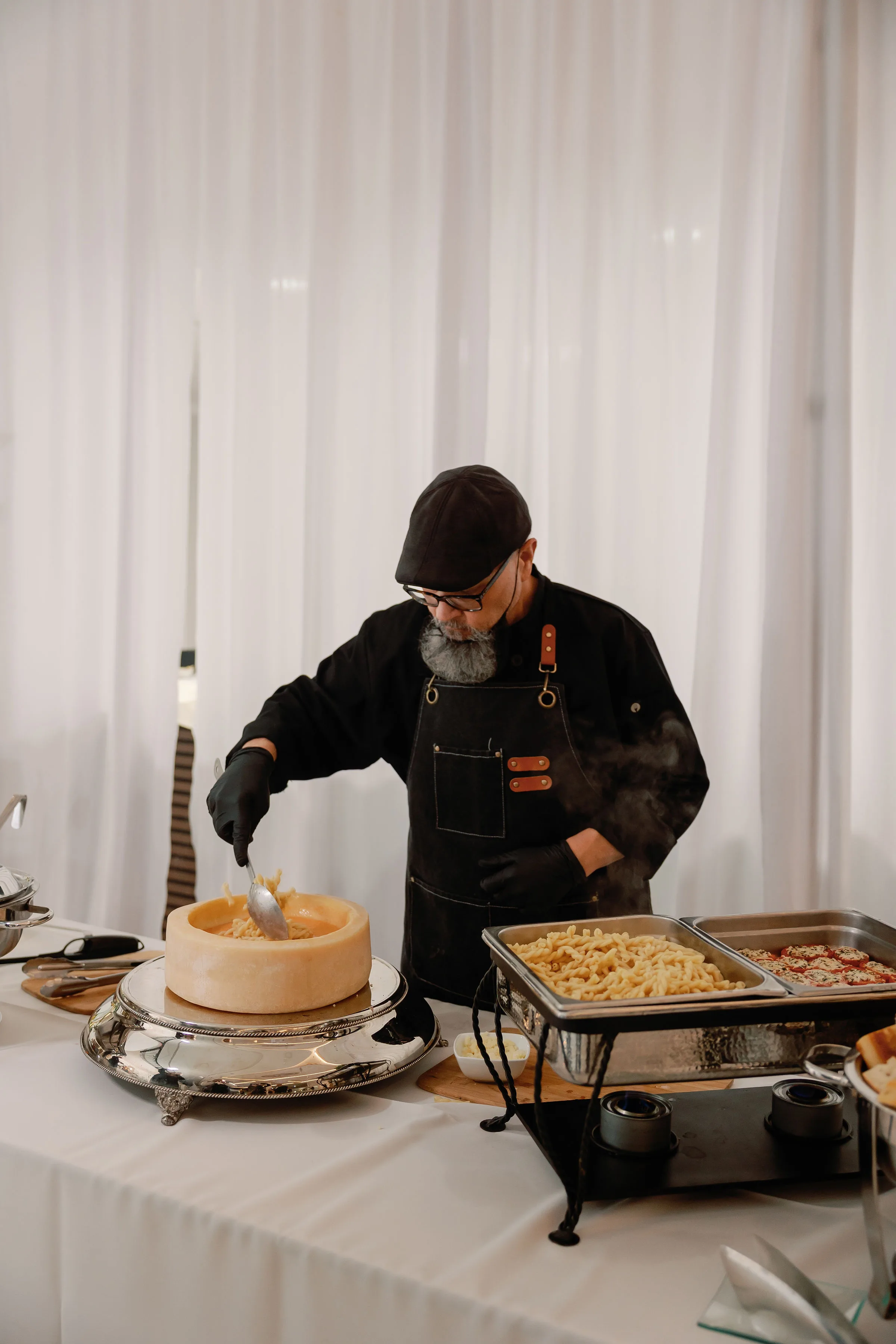 Professional chef from A Catered Affair serving fresh pasta from a parmesan cheese wheel at Nashville wedding reception