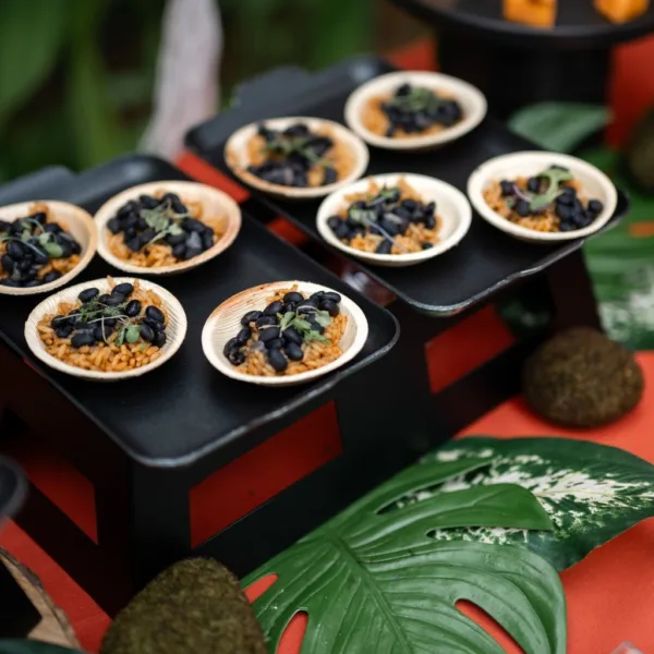Elegant wedding appetizers with black olives and grains served in wooden boats by Nashville caterer A Catered Affair