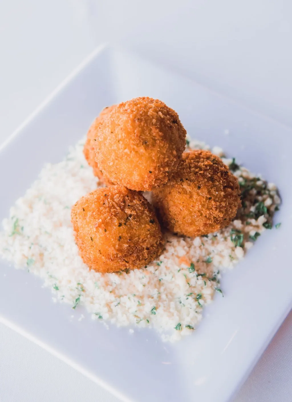 Golden fried arancini risotto balls with herbs and parmesan cheese served by Nashville wedding caterer A Catered Affair
