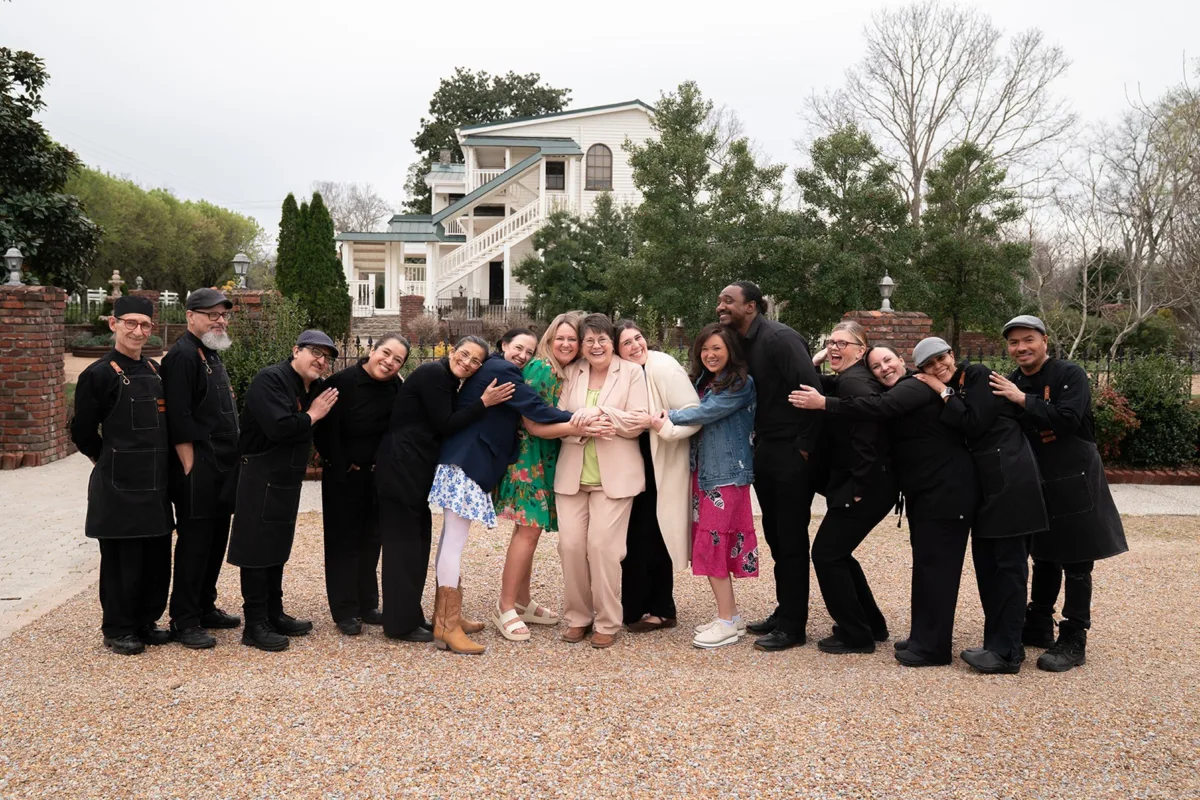 Wedding catering team and guests group photo at historic Nashville venue showcasing A Catered Affair professional service