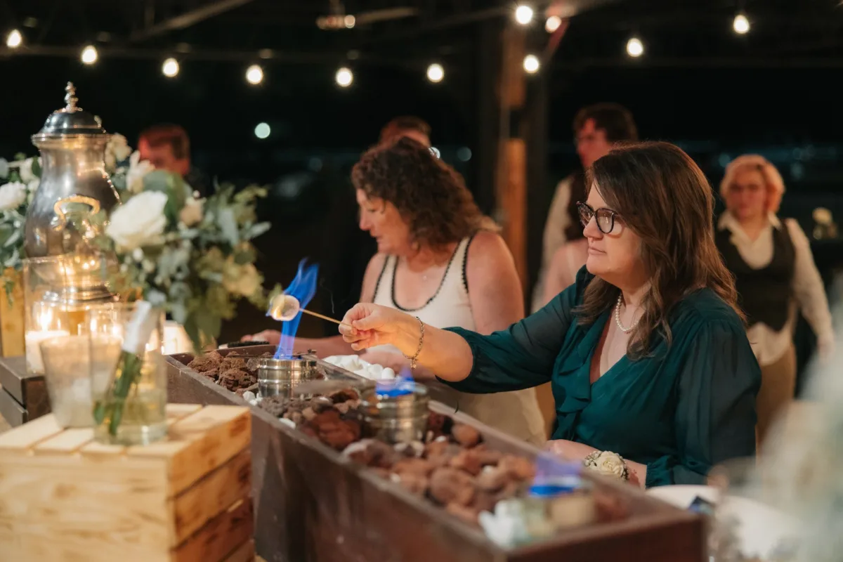 Wedding guests enjoying interactive s'mores dessert station catered by A Catered Affair at Nashville wedding reception
