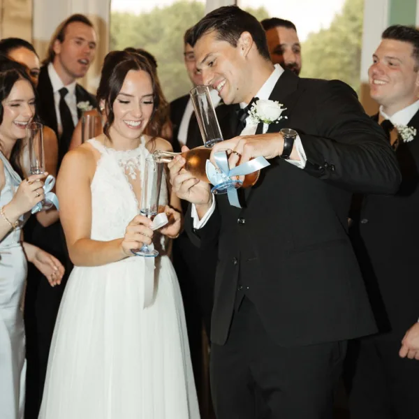 Bride and groom sharing champagne toast with wedding party at Nashville wedding reception catered by A Catered Affair
