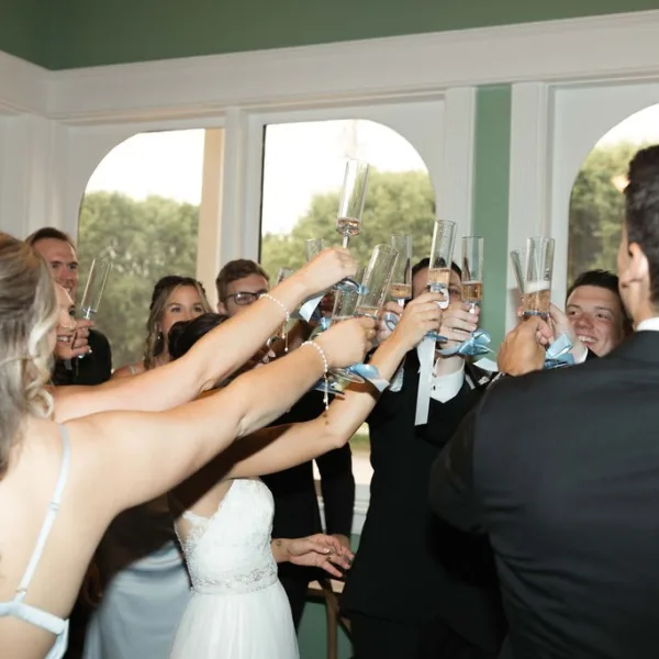 Wedding party raises champagne glasses in celebratory toast at Nashville wedding catered by A Catered Affair