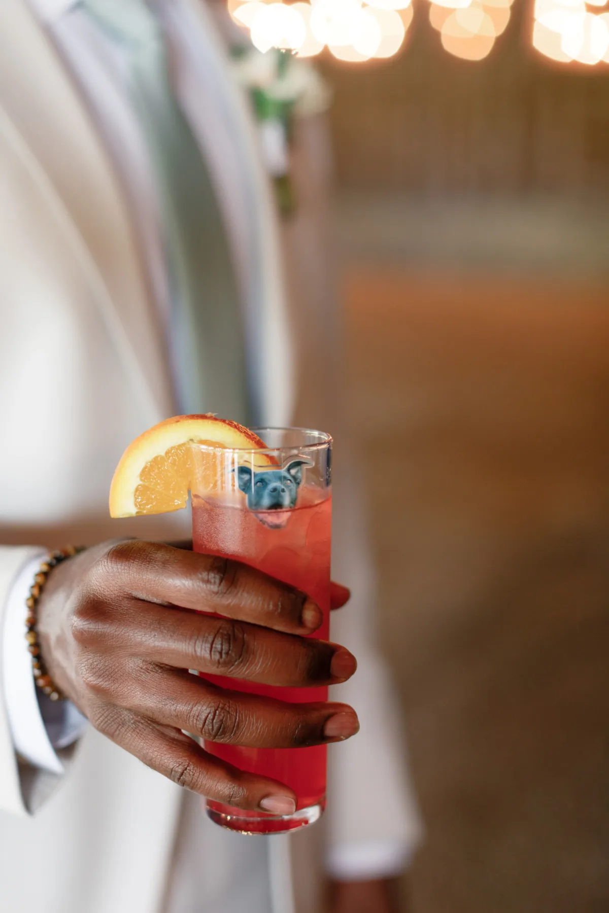 nashville wedding cocktail signature drink catered affair - Beverages Hand holding red signature wedding cocktail with orange garnish at Nashville wedding catered by A Catered Affair