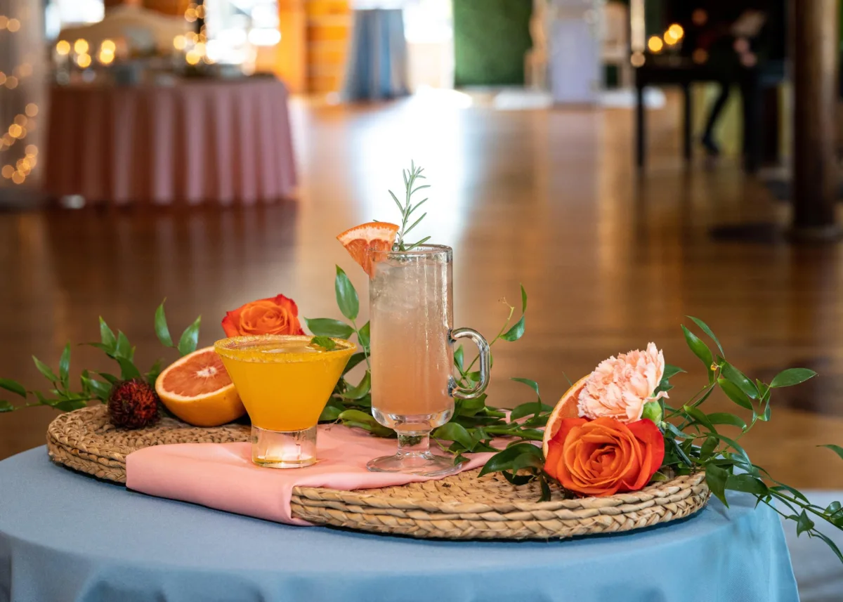 nashville wedding cocktails floral styling catered affair - Beverages Elegant wedding cocktails with orange martini and grapefruit mule garnished with fresh florals and citrus on woven chargers for Nashville wedding catering by A Catered Affair