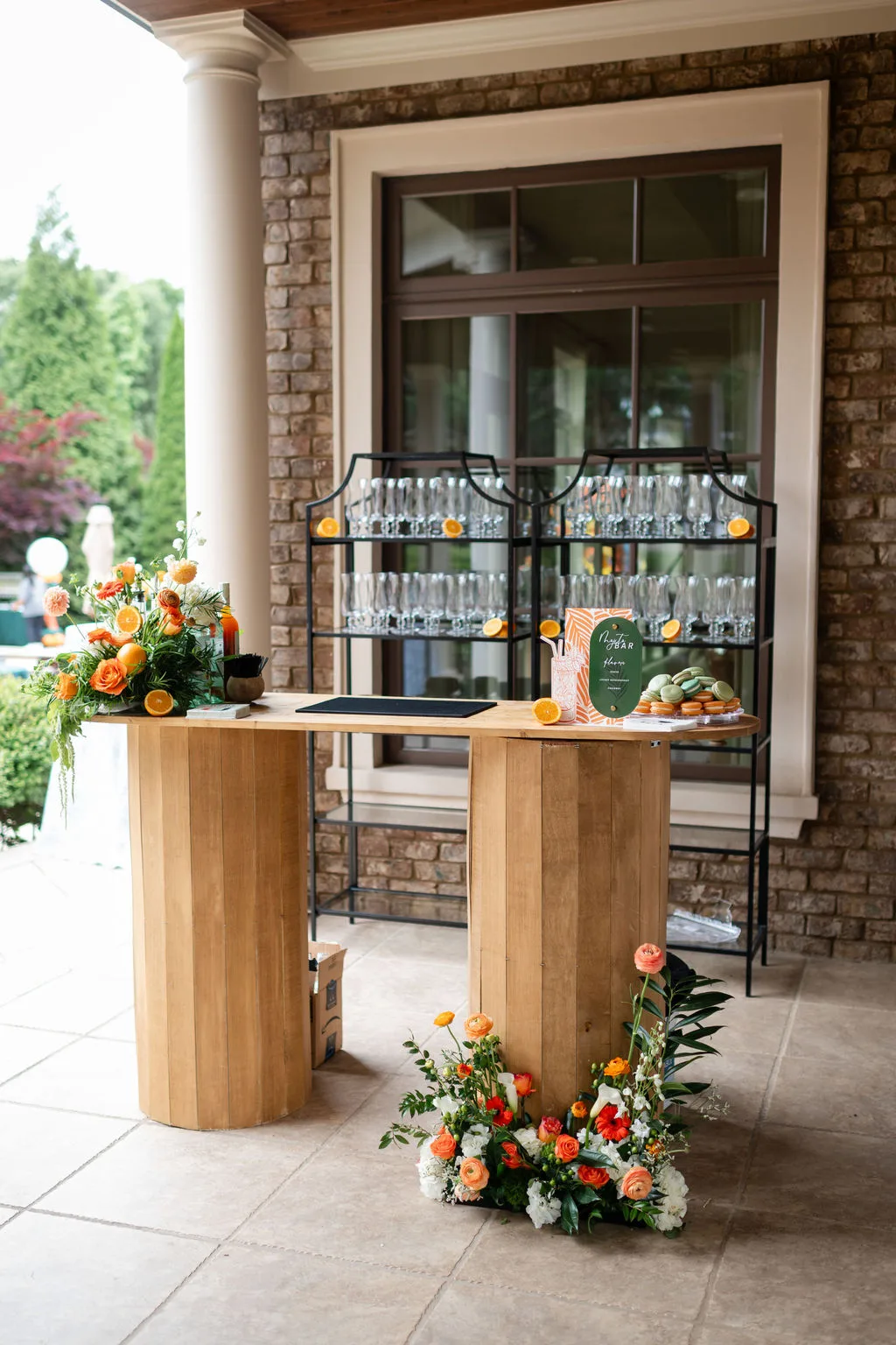 outdoor wedding bar setup private event catering - Nashville Private Event Catering Elegant outdoor wedding bar station with champagne flutes, orange floral arrangements, and wooden pedestals at Nashville private event by A Catered Affair