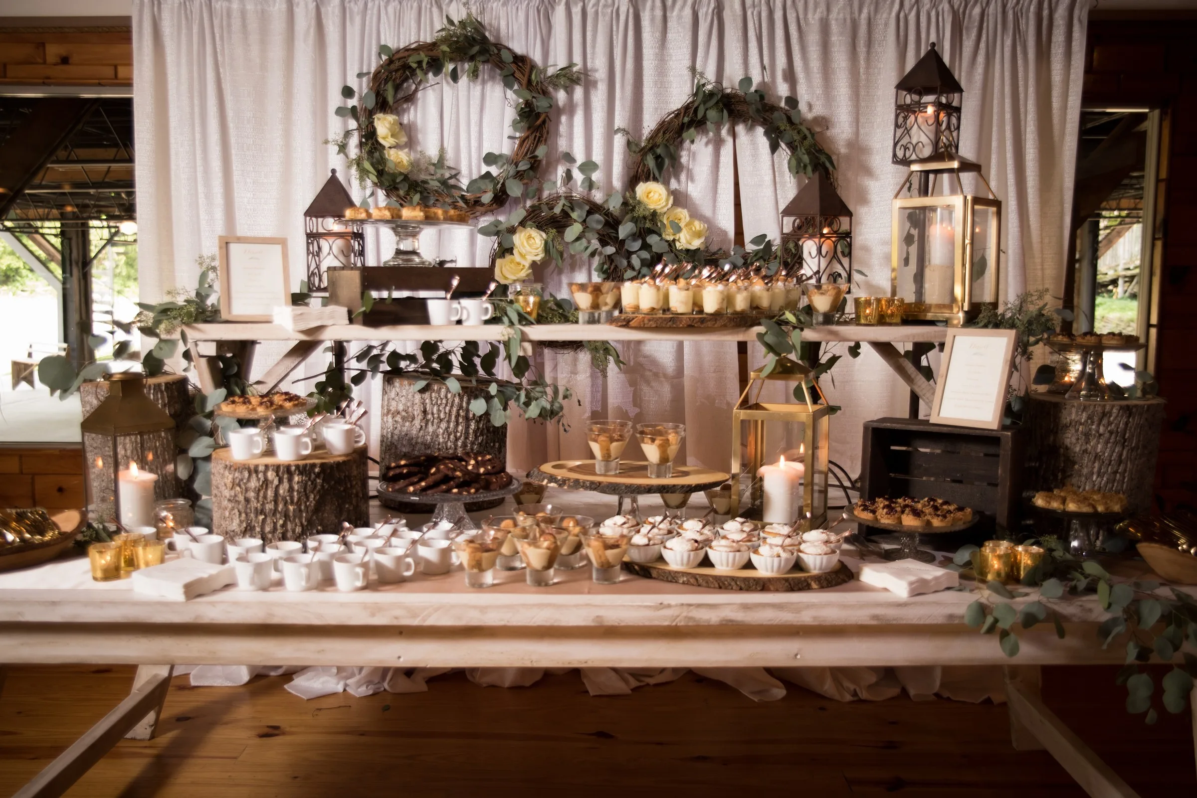 rustic dessert table wedding catering nashville a catered affair - Desserts Elegant rustic dessert table with lanterns, greenery wreaths, and tiered displays catered by A Catered Affair for Nashville wedding