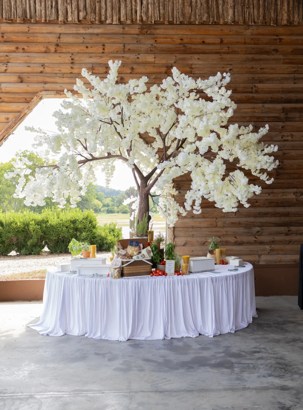 Elegant wedding catering display table with white floral tree centerpiece and appetizers at rustic Nashville venue by A Catered Affair