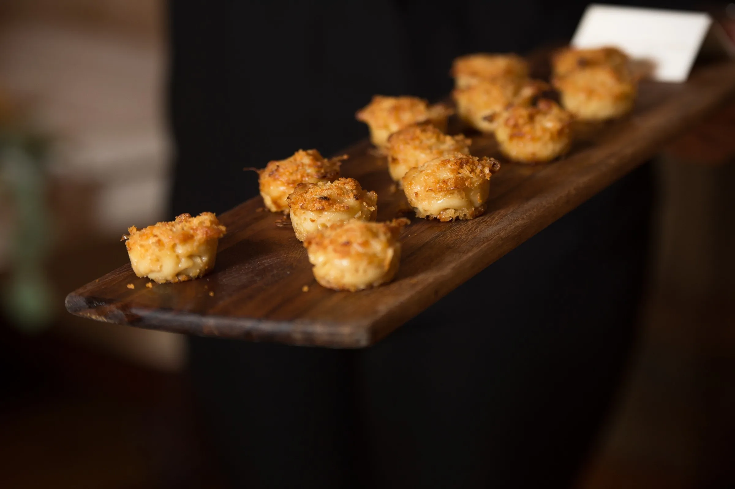 Elegant golden baked appetizers served on wooden board by Nashville wedding caterer A Catered Affair