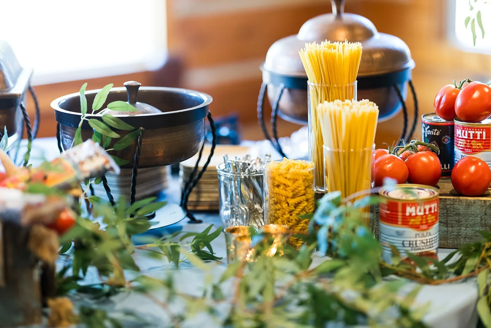 Elegant wedding catering pasta station with fresh tomatoes, spaghetti, and Italian ingredients by A Catered Affair in Nashville