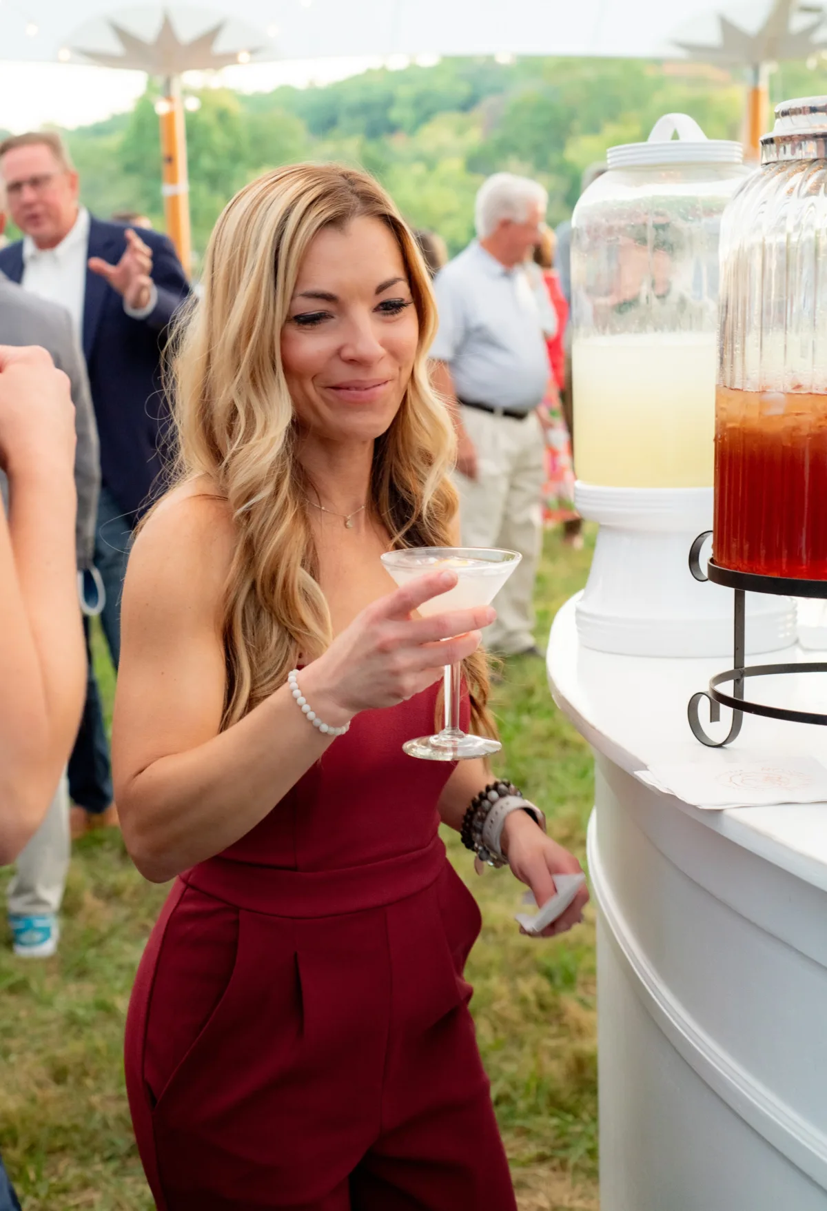 Wedding guest enjoying cocktail at outdoor reception with professional beverage service by A Catered Affair Nashville wedding caterer