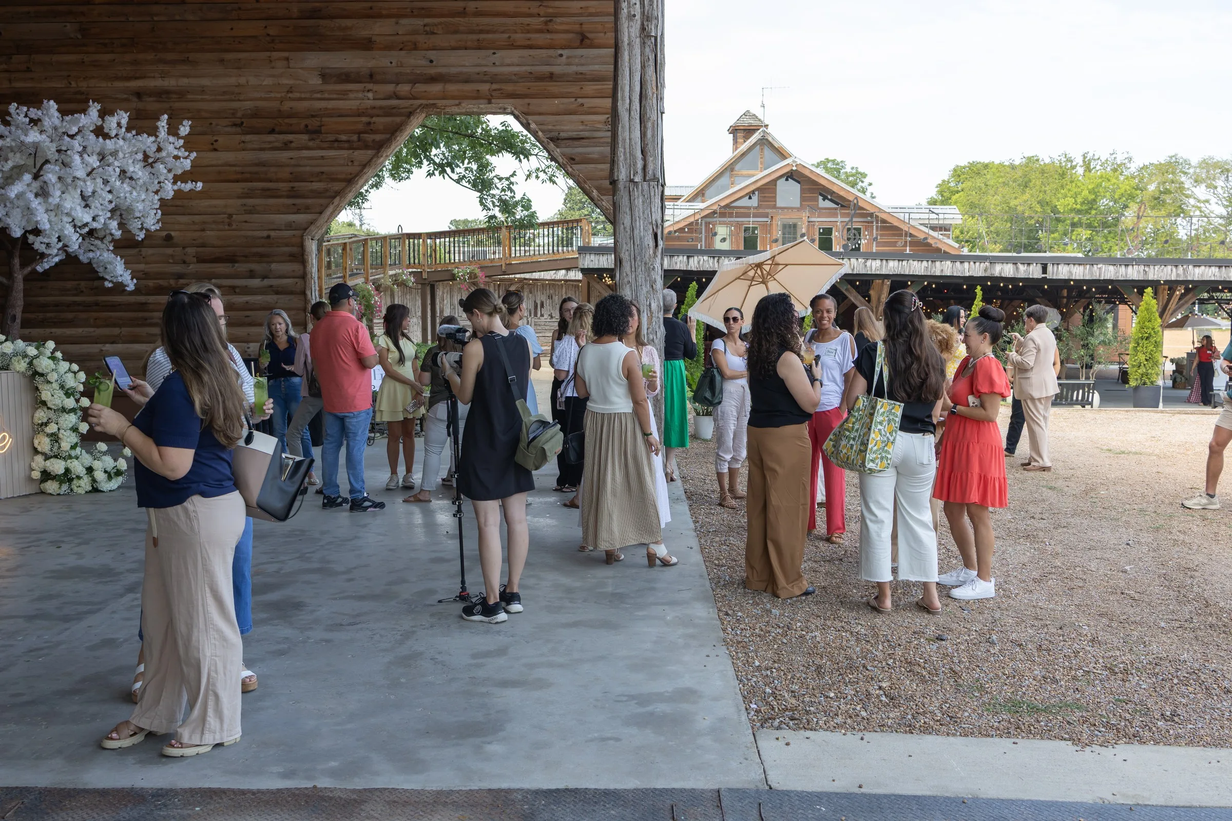 Wedding guests enjoying cocktail hour at rustic Nashville wedding venue with wooden architecture and outdoor ceremony space